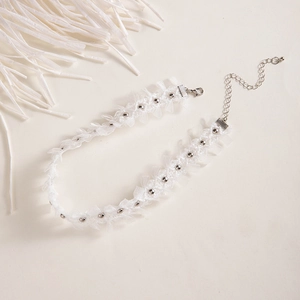 Detail of white tulle choker featuring silver metallic beads and adjustable clasp