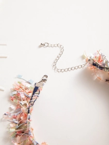 Macro detail of bohemian colorful tassel necklace with silver lobster clasp and extension chain