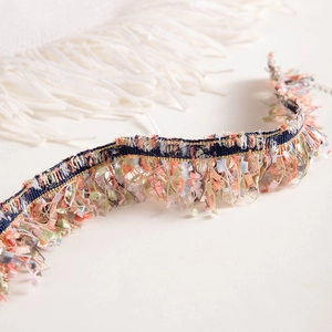Detail of colorful lace woven choker with tassels in pink, green, and navy blue