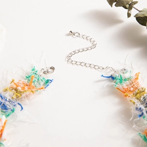 Detail of colorful woven lace necklace with lobster clasp and metal extension chain