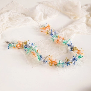 Close-up of colorful lace woven choker with fluffy fibers and metal lobster clasp detail