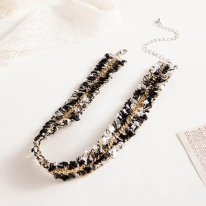 Detail of woven lace choker with gold chain texture on vintage newspaper background