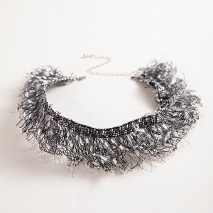 Macro shot of black and white woven lace choker with feather fringes and sequin details