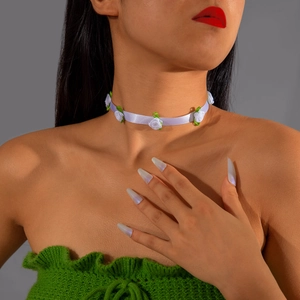 Detail of white lace ribbon choker with fabric roses and green leaf accents on neck