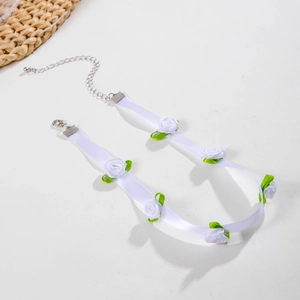 Close-up of white lace fabric rose choker with delicate green silk leaves and metal clasp