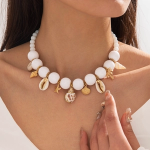 Close-up of bohemian shell and starfish charms on a pearl-like beaded summer necklace