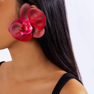Detail of dark red orchid earring with realistic velvet texture on a female model