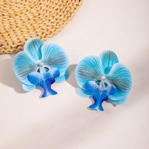 Macro detail of blue orchid flower earrings with realistic fabric petals and texture