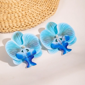 Close-up of blue orchid flower earrings with detailed petal textures and gradient tones