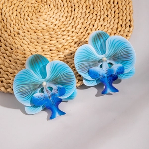 Macro detail of blue orchid earrings with realistic texture on a rustic woven background