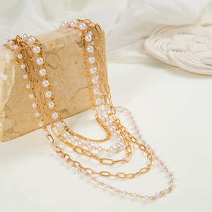 Multilayer gold alloy chain necklace with pearls on a stone stand lifestyle display