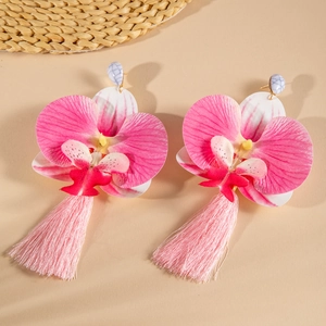 Detail of pink orchid earrings with lifelike textures and long silk tassels in warm light