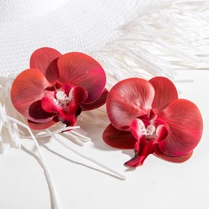 Deep red orchid earrings with realistic petal texture and elegant white speckled details