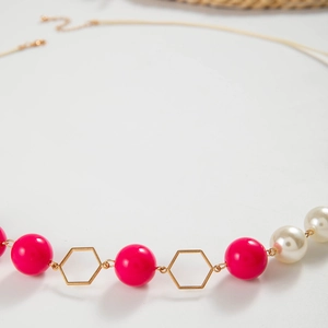 Detail van bloemenketting met magenta kralen, witte parels en gouden zeshoeken