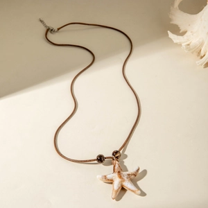 Detail van zeester hanger ketting met bruin geweven koord en marmeren textuur
