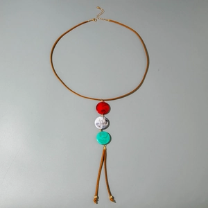 Detail van lange bohemien ketting met kleurrijke marmeren harsringen en leerkoord