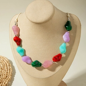 Detail van kleurrijke boho kralenketting met onregelmatige gemarmerde harskralen