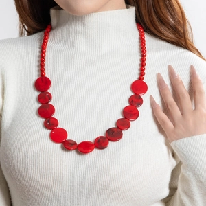 Detail van een rode kralenketting met bloemvormige hars hangers met marmeren textuur