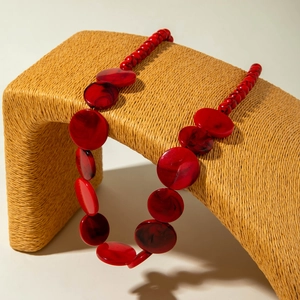 Macro-opname van lange bohemien ketting met rode marmeren textuur en ronde kralen