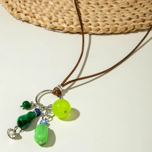 Detail van kleurrijke kralen met groene kalebas hanger aan lange ketting met bruin touw