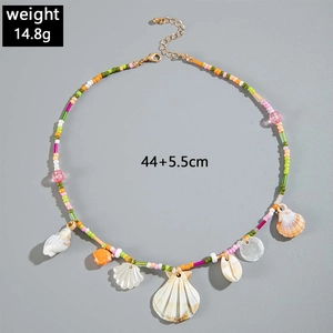 Flat lay of colorful ocean-themed beaded necklace with seashell and scallop charms