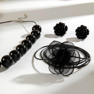 Dettaglio della collana di perle acriliche nere con grande ciondolo a rosa in rete 3D