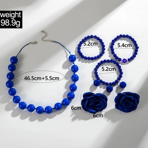 Dettaglio di set di gioielli blu scuro con perline acriliche e rose in tessuto blu