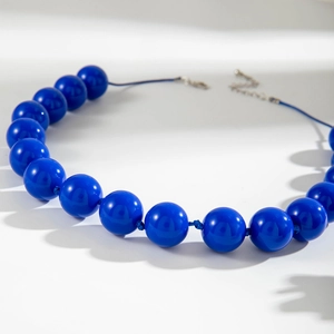 Dettaglio macro della collana di perline acriliche blu reale con chiusura a moschettone