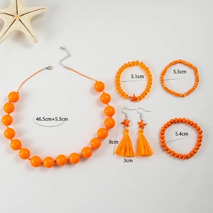 Dettaglio del set di gioielli in acrilico arancione con collane, bracciali e orecchini