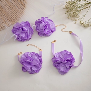 Dettaglio del set di gioielli con rose in tessuto viola con nastro di raso e perle