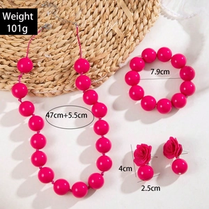Dettaglio set gioielli con perle fucsia e orecchini a rosa in tessuto boho style