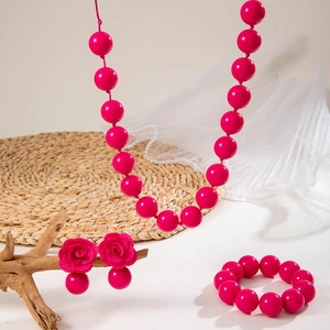Set dettagliato di gioielli con perle rosa acceso, collana, orecchini rosa e bracciale