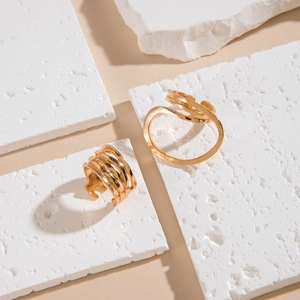 Detail view of gold irregular curved rings on minimalist white stone display slabs