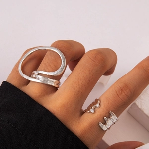 Detailed macro of silver-toned irregular wrap rings set with hammered liquid metal texture