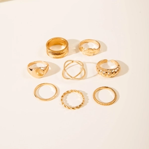 Detailed view of 8-piece gold-toned minimalist stackable ring set on white surface