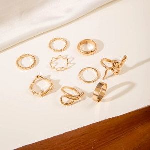Flat lay of a 9-piece gold minimalist ring set with wave and snake designs on silk