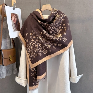 Détail de l'écharpe marron café avec imprimés floraux beige et bordures à fines franges