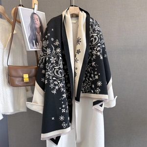 Détails du motif floral sur châle en maille avec franges pour un look hivernal chic