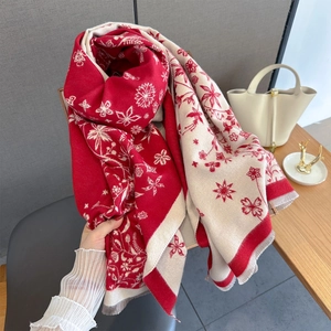 Détail du motif jacquard floral et des franges douces sur ce châle rouge effet cachemire