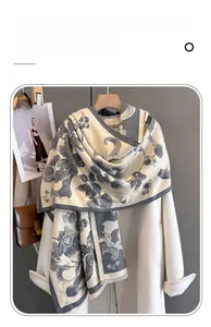 Detail of peony floral scarf with fringe trim, shown against a gray background with magazine