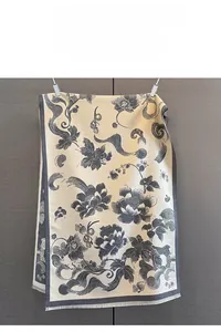 Detail of floral peony print and delicate fringe tassel on warm cashmere-like shawl