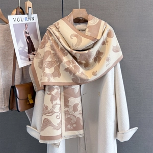 Detail of vintage floral cashmere-feel shawl with fringe tassels on a white winter coat