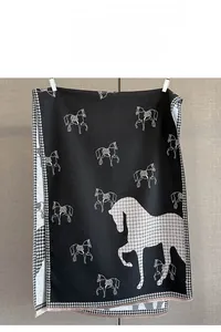 Detailed view of horse patterns and houndstooth texture on thick cashmere-feel scarf