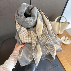 Detail of grey cashmere-like shawl featuring horse patterns and houndstooth texture