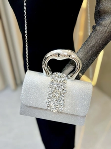 Détail du sac de soirée argenté étincelant avec boucle en strass et poignée métallique