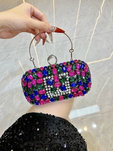 Macro shot of colorful oval rhinestones and silver metal ring handle on luxury evening bag