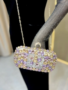Detail of luxury evening clutch bag with purple and champagne rhinestones on velvet