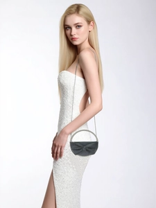 Detailed view of luxury black bow evening bag with sparkling rhinestones and chain strap