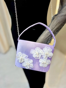 Détail du sac de soirée en satin lilas avec broderies florales et perles blanches