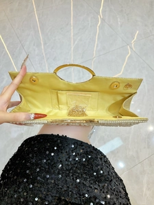 Sparkling evening clutch bag with pearl inlay and golden ring handle shown open